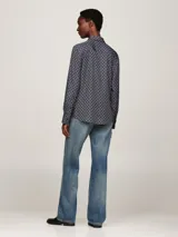 Camisa azul con estampado de rombos blancos, cuello con lazo y mangas largas.