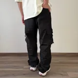 Pantalón cargo tipo parachute de color beige, con calce baggy, bolsillos laterales con solapa y cordones ajustables en los tobillos.