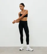 Calza deportiva tipo legging de tiro alto, color negro, confeccionada en microfibra térmica con bolsillo lateral funcional. Diseño liso y ajustado al cuerpo.