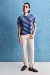 Remera de calce relajado con diseño a rayas horizontales blancas y verdes, hombros caídos y mangas amplias con vuelta. Presenta cuello redondo y ruedo trasero levemente más largo.