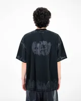 Remera de algodón heavyweight con corte oversize, color negro con efecto lavado y estampado gráfico frontal con tipografía estilo metal y texto motivacional.