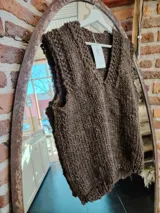 Chaleco de lana marrón tejido a mano con cuello en V y sisas amplias. Diseño clásico y versátil.