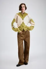 Pantalón de tiro medio confeccionado en tejido de pana, con diseño de pierna ancha, bolsillos delanteros y traseros, y cierre frontal con cremallera y botón.