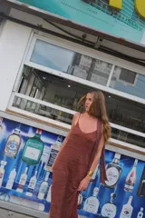 Vestido largo de tejido de punto, color ladrillo, con breteles finos regulables, espalda abierta y tajos laterales en el ruedo. Incluye una bufanda del mismo tejido y color.