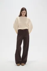 Pantalon de jean de corte ancho y tiro medio, en color natural, con cierre frontal y bolsillos laterales.