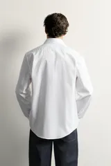 Camisa slim fit de algodón blanco con cuello italiano y manga larga con puño abotonado. Cierre frontal con botonadura.