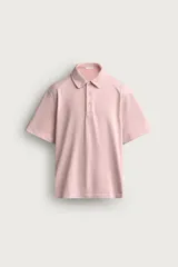 Polo de corte regular fit en color rosado con efecto lavado. Presenta cuello solapa, cierre frontal de botones y mangas cortas con acabados en rib.