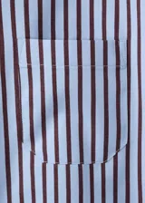 Camisa de corte recto con diseño de rayas, cuello camisero, manga larga con puños abotonados, bolsillo de parche en el pecho y cierre delantero con botones.