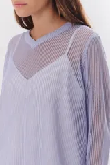 Sweater de tejido de punto calado color lila, con cuello en V y mangas largas.