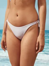 Conjunto de bikini lila con corpiño triangular con lazo ajustable en el centro y bombacha con tiras laterales.