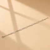 Pulsera de plata 925 con diseño de eslabones intercalados entre dijes circulares calados con forma de hojas.
