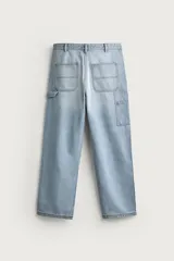 Pantalón jeans relaxed fit de mezclilla azul oscuro, con estilo carpintero que incluye bolsillos laterales y presillas de herramientas. Cuenta con costuras pespuntadas en contraste y cierre frontal con botón y cremallera.
