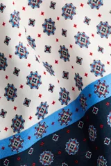 Top halter confeccionado en viscosa satinada de corte evasé, con cuello elevado, cintas para enlazar en la nuca, bajo redondeado y estampado geométrico en tonos azul marino, celeste y blanco.