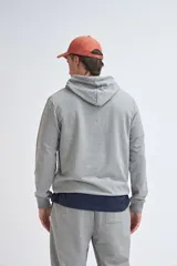 Hoodie deportivo gris melange con capucha, confeccionado en tejido cómodo y versátil.