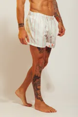 Short de baño rosado con estampado tropical de palmeras y vehículos, con cintura elástica con cordón ajustable.