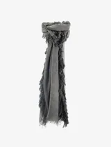 Pañuelo fino de tejido ligero, color gris, con flecos largos y densos en los bordes laterales y flecos más cortos en los bordes superiores e inferiores.