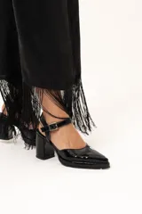 Sandalia de punta cerrada con taco cuadrado y pulsera al tobillo con hebilla ajustable, confeccionada en cuero negro con acabado charol.