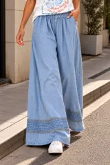Palazzo de denim celeste claro, de corte wide leg, con cintura elástica y detalle de bordado decorativo en el ruedo.