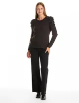 Buzo de tejido soft color gris oscuro, con cuello redondo y mangas largas. Presenta hombros con diseño plisado y detalle de perlas aplicadas.