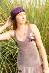 Vestido corto negro con estampado de plumas doradas, escote en V, breteles finos cruzados en la espalda, cut-outs laterales y volado en el ruedo.