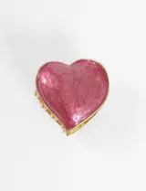 Broche metálico con forma de corazón y acabado simil nácar color rosa.