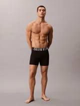Pack de tres bóxers largos de microfibra en color negro, tiro medio y ajuste ceñido. Cuentan con cinturilla elástica distintiva de la marca Calvin Klein con el logotipo en contraste de colores rojo, blanco y gris.