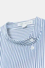 Camisa de algodón con estampado de rayas verticales azules y blancas. Presenta cuello mao, cierre frontal con botones a contraste y mangas cortas abullonadas con puños rectos.