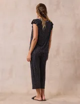 Conjunto de pijama marca René Rofé, compuesto por una remera de escote en V con botones y un pantalón capri con cintura elastizada, ambos en tejido soft estampado con motivos florales en tonos celeste y blanco.