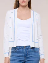 Cardigan de punto fino color blanco, con detalles de bordados florales en tono celeste, mangas largas y frente abierto con ribetes celestes.