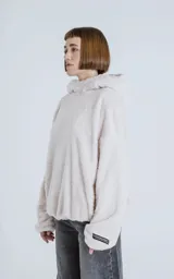 Hoodie oversize de piel sintética tipo corderito, color off-white, con capucha ajustable y bolsillo canguro frontal.