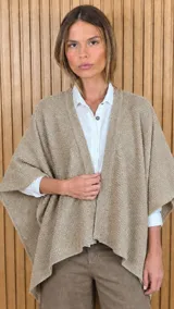 Ruana de tejido de punto de algodón con hilo de lurex, color tostado con sutil brillo dorado, diseño abierto y mangas amplias.