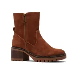 Bota de caña media confeccionada en cuero gamuzado color beige, con cierre lateral metálico, taco cuadrado de madera y suela track dentada.