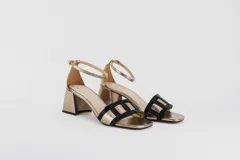 Sandalias doradas con taco bloque de 5 cm y capellada combinada en dorado y negro.