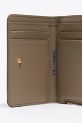 Billetera compacta de estructura blanda en color turquesa, con cierre de cremallera superior y logo metálico dorado en el frente.