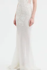 Vestido largo de tul con bordados florales al tono, escote en V profundo y diseño ajustado en el torso con falda fluida.