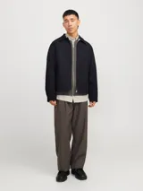 Campera aviadora negra de corte clásico, con cuello camisero, cierre frontal con cremallera, bolsillos laterales y puños ajustados. Confeccionada en tejido plano de poliéster y algodón.