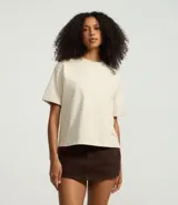 Remera de manga corta color crema, con cuello redondo y corte oversized.