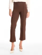 Pantalón cigarette de tiro alto color marrón, confeccionado en tejido elastizado. Presenta un diseño de pretina ancha y plana sin cierres, con costuras verticales pronunciadas a lo largo de cada pierna y corte recto al tobillo.