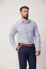 Camisa de vestir a rayas verticales azules y blancas, de corte entallado, con cuello clásico y puños abotonados.