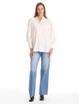 Camisa de color rosado con cuello clásico y cierre frontal de botones. Presenta mangas largas con detalles calados y puños anchos abotonados.