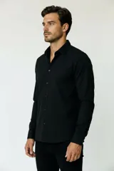 Camisa de poliéster color marrón, de corte holgado, con mangas largas, cuello camisero clásico y cierre frontal de botones.