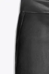 Shorts mini de tiro bajo confeccionados en tejido efecto piel. Presentan un diseño estructurado con cierre frontal de cremallera, botón interior y ganchos metálicos ocultos.