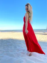 Vestido largo rojo con breteles finos amarillos con estampado floral negro y espalda descubierta.