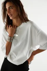 Remera blanca de algodón ultrasuave, con cuello redondo, diseño oversize y hombros caídos de corte recto.