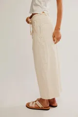 Pantalón de denim blanco de tiro medio con cintura elástica ajustable mediante cordón, bolsillos plaqué delanteros y diseño de corte amplio y holgado.