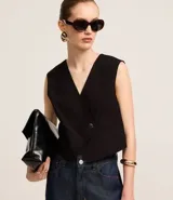 Chaleco negro de sastrería con escote en V cruzado y botón de resina.