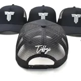 Gorro negro tipo trucker con paneles frontales rígidos y paneles traseros de malla. Presenta un logo bordado en blanco en el frente.