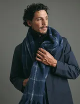 Bufanda de estilo escocés con textura, diseño clásico a cuadros y flecos en los extremos.