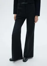 Pantalon de vestir negro con diseño acampanado, tiro medio, cierre oculto y bolsillos laterales.