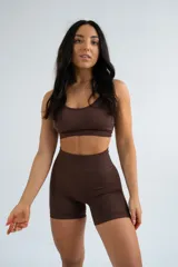 Top deportivo negro de breteles finos cruzados en la espalda, con diseño ajustado y escote redondo.